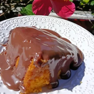 Pedaço generoso de bolo de cenoura com calda de chocolate