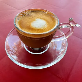 Macchiato com pequena porção de microespuma servido em xícara de vidro