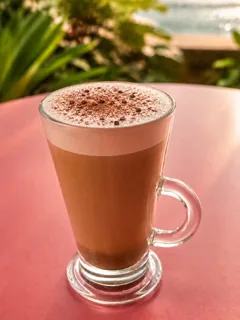 Mocha com chantilly e raspas de chocolate servido em caneca alta de vidro
